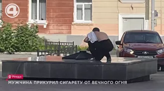 Мужчина прикурил сигарету от Вечного огня Мужчина прикурил сигарету от Вечного огня